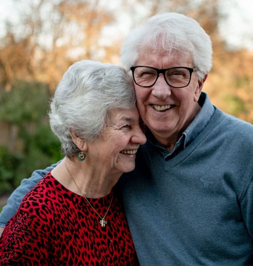elderly couple hugging in retirement
