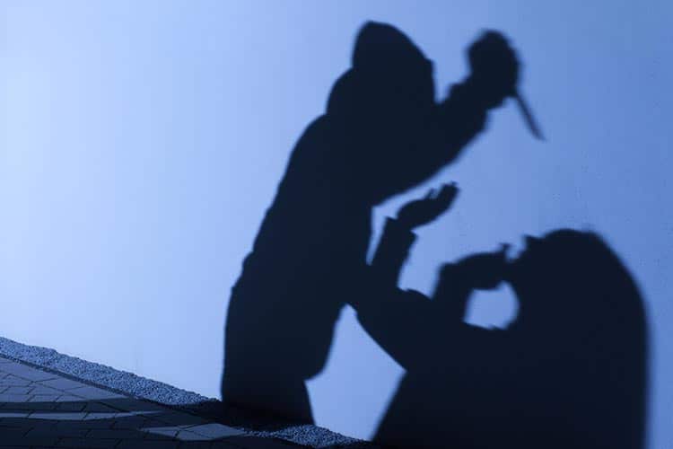 Silhouette Of Man Holding A Knife Attacking A Woman