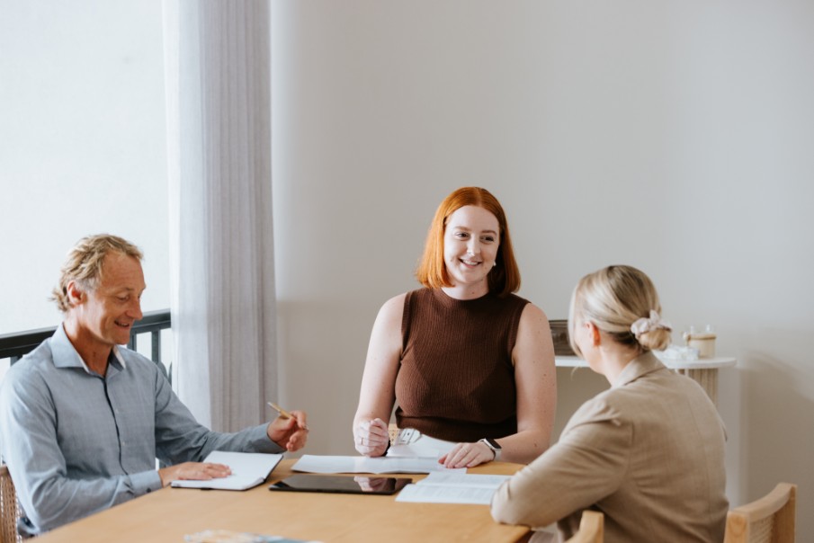 Smiling red haired female legal professional chatting with blond female client