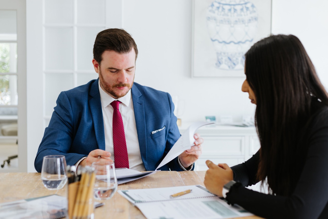 Male lawyer in suit reviewing contract on table