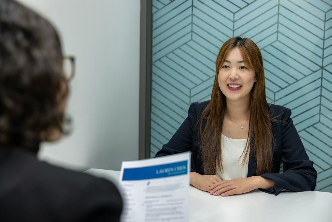 Long haired smiling female being interviewed for a job