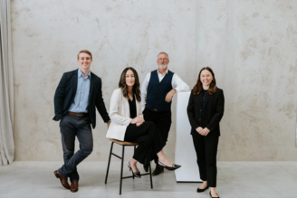 Four solicitors standing in a stone coloured room
