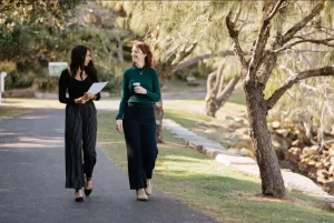 estates two female professional talking while walking in the road