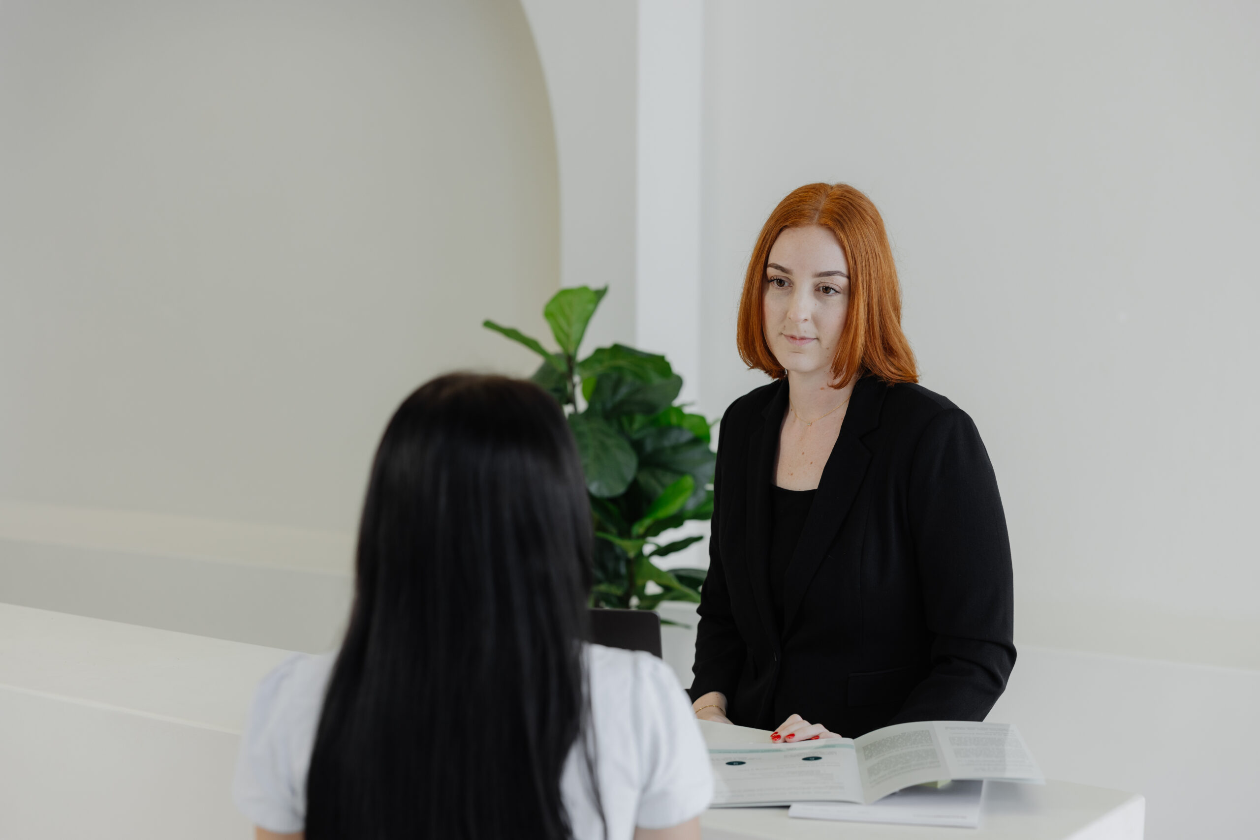 Red-haired female smiling at will solicitor