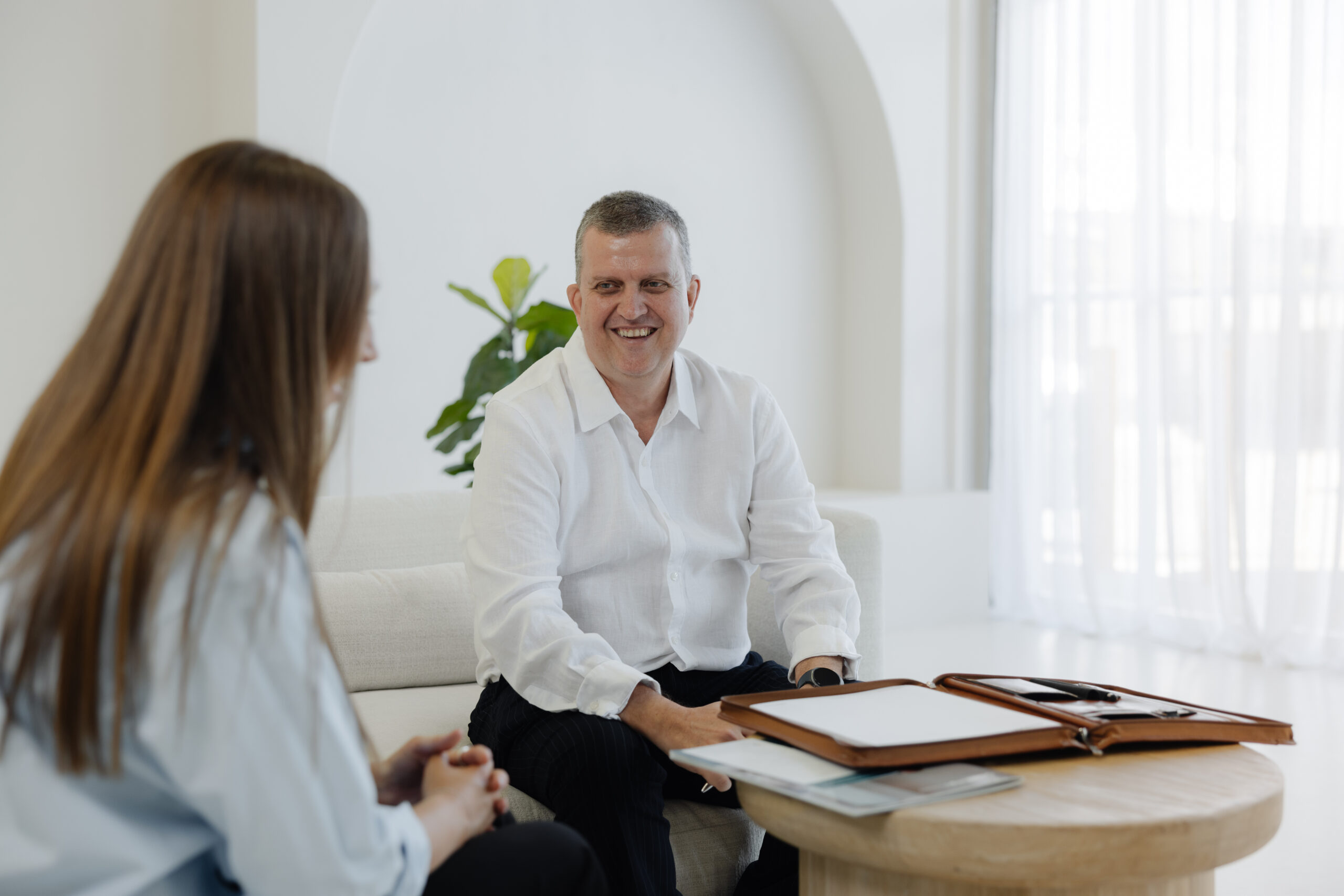 Young male accountant showing female graph on tablet